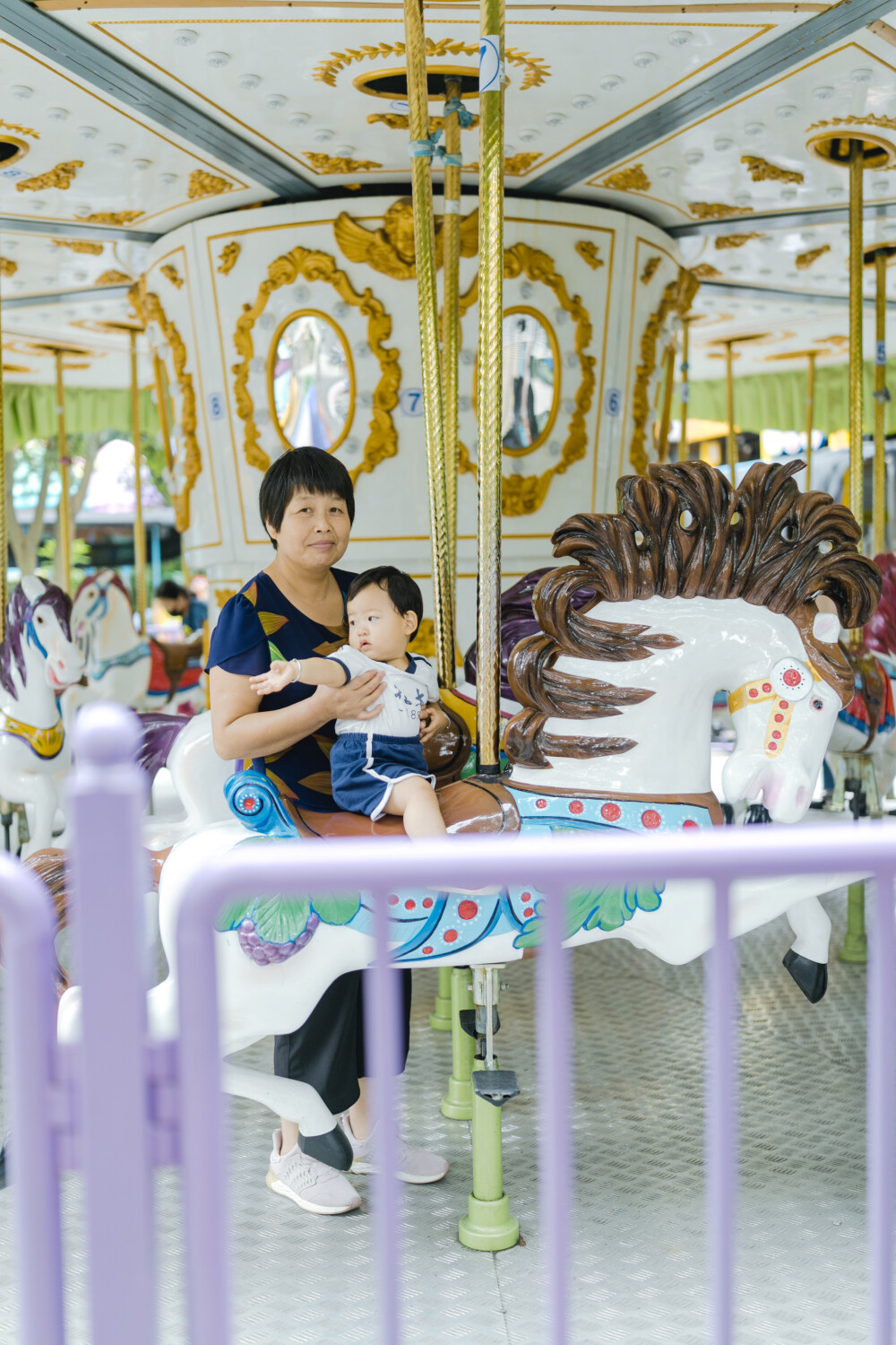 少年宫似乎不太适合你
摄影：洪小漩
出镜：菲比和奶奶
在有孩子之前，我也常去少年宫。主要是贪恋那边的童趣。
不过，我从未办卡消费过。托菲比的福，我办了一张卡，在我虚岁32岁这一年。
我满心欢喜以为菲会兴奋地咯咯直笑。事实上，我失策了。她全程都是一副“陪我妈玩得好累”的样子，多少让我有些受挫。
玩了多个旋转类的游乐设施，我和菲比的奶奶都有些晕乎，几乎快吐了。可是菲比还是一副面无表情的样子。这让我发现，我除了感动自己，简直一无是处。
我和婆婆最后选择了放弃，任由她在少年宫闲庭信步。然后，我们意外发现，她喜欢一个人漫无目的跑来跑去。她一边蹒跚跑步，身边还会有人看着她的衣服逗趣：呦呵，北