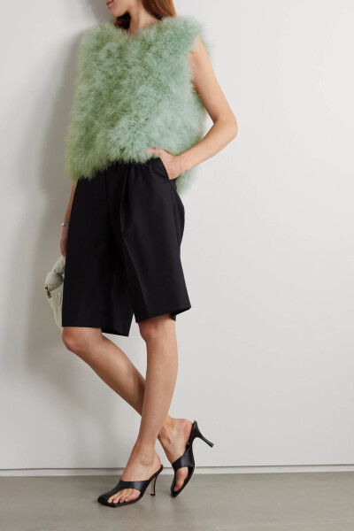 Dries Van Noten 2021 秋冬系列从华丽梦幻的戏剧世界中广泛取材，自然运用了大量的羽毛元素。这款 “Taffy” 上衣采用柔软的羊毛制成，版型略微宽松，衣身覆满蓬松舞动的薄荷绿色羽毛。品牌推荐与丝滑的贴身半裙同穿…