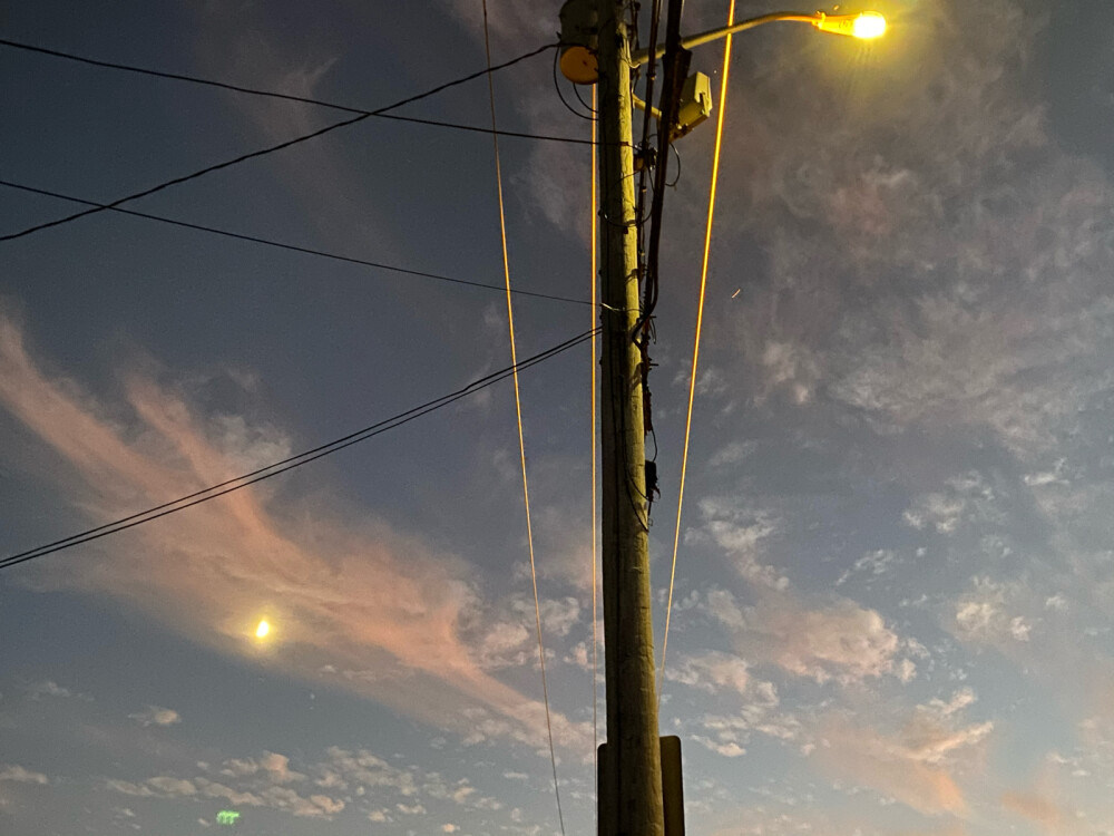 日落过渡到夜晚时的天空、月亮和街灯。