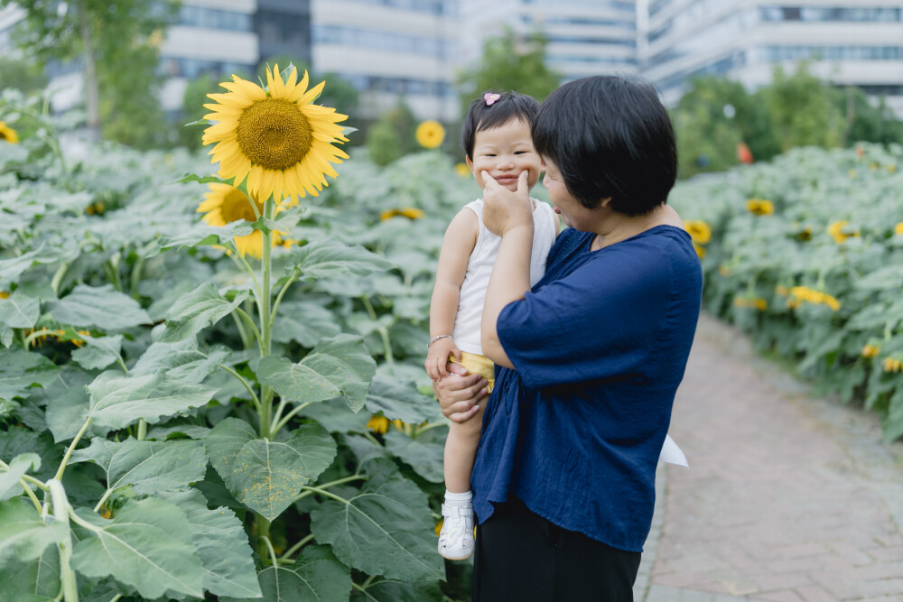 奶奶的小胶布
摄影：洪小漩
出镜：菲比和奶奶
也不知道菲比那天到底怎么样，一放到地上就放声大哭，然后蹒跚追赶着奶奶要抱抱。
婆婆说，你今天怎么了呢，怎么变得粘人了呢。说着，顺势将菲比揽入怀中，用左手大拇指和食指顶着菲比的脸颊，希望支撑出一个笑脸的弧度。奈何，她不配合。
怀孕期间，阿科便征求我同意，问婆婆几时过来照顾我比较合适。对此，我一直举棋不定，只推说自己身体尚佳，不用劳烦长辈提早过来。
最终，直到预产期前的两周，婆婆提着不大的包，住进了我们租住的房子。两口之家，自此，变成了三口之家。
听从医生的建议，预产期前的大约一个月我便请了家在家。自从婆婆来后，没到阿科去上班的时间，便是