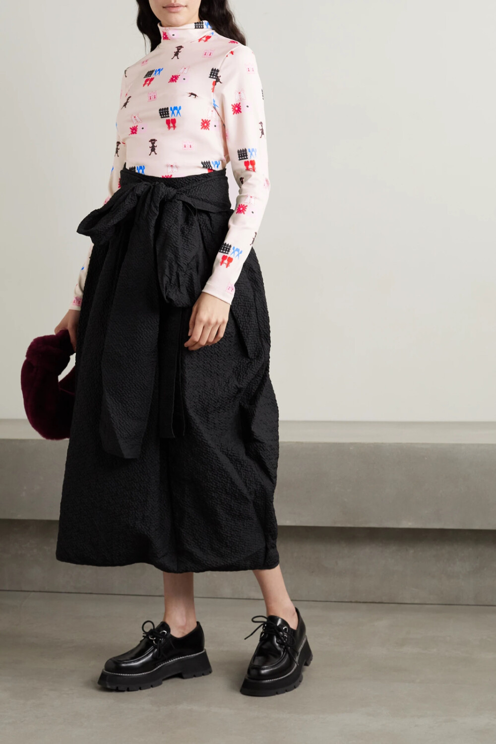 MINJUKIM 的创始人对图案和色彩有着天生的敏锐嗅觉，这也帮助她最终赢得网飞综艺《时尚的未来》的冠军。其中这款出自 2021 秋冬系列的高领上衣饰有大面积图案印花，色彩鲜明，设计独特。修身的平纹衣身柔软又富有弹力，适合叠搭。