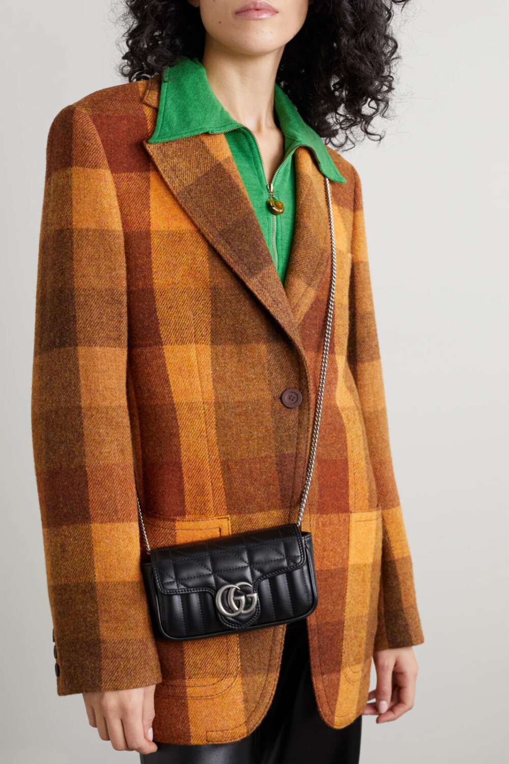 Gucci 的 “GG Marmont” 包袋家族再添一员得力“小将”，这一新款手袋虽然身量迷你，仅能容下你的随身小物，却紧跟当下小包潮流，释放出不容小觑的时髦能量。此单品诞生于意大利，以绗缝皮革制成，饰有品牌标志性的饰牌，链条肩带还能对折缩短。不妨以银色珠宝呼应包身上的五金装饰。