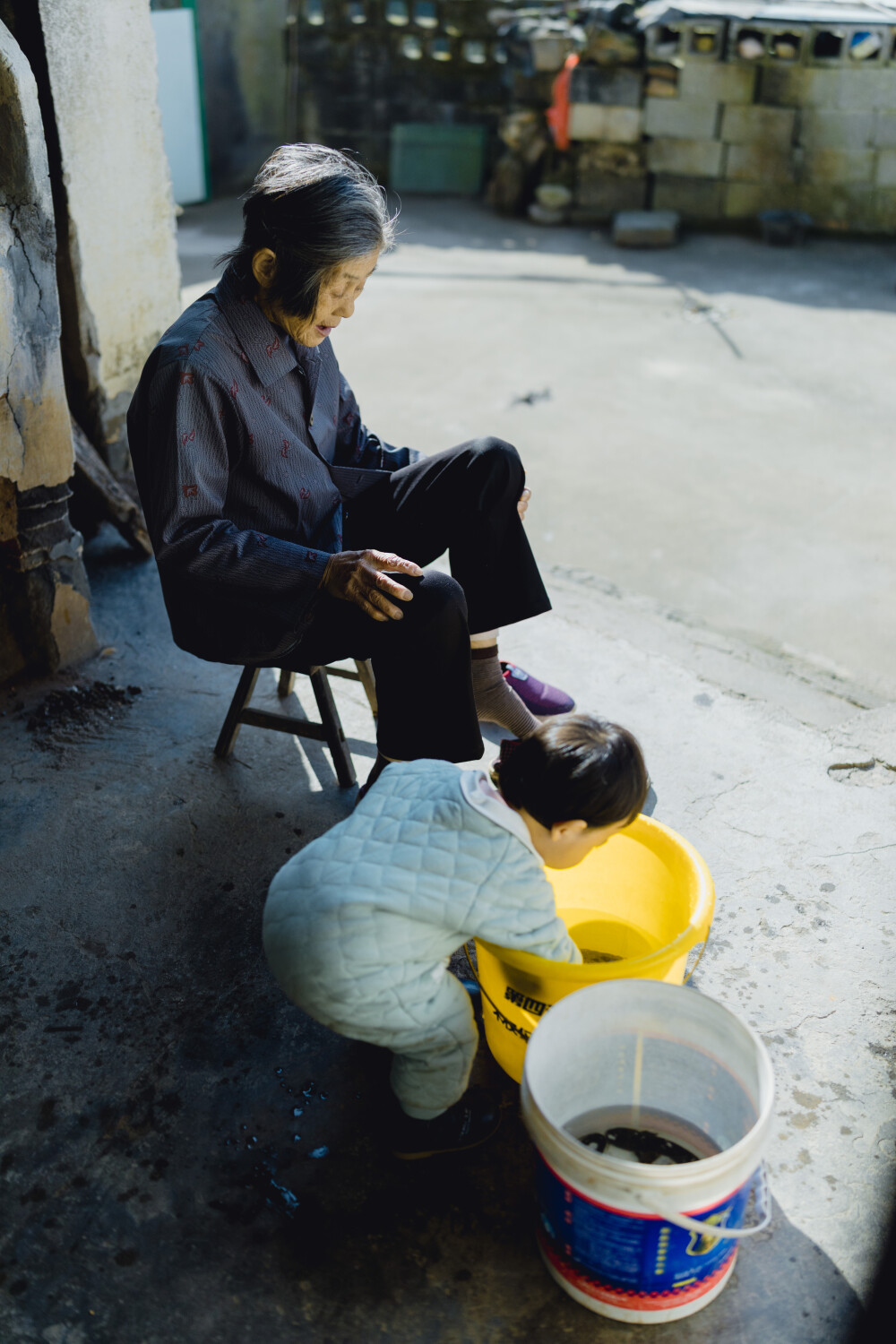 承欢阿太膝下
摄影：洪小漩
出镜：家人
小家装修好不多时，为了安全起见，还是决定暂且送菲比回了乡下小住几周。先是在阿科外婆家待了两周。上周末，我们赶回去从外婆家提上大包小包的行李，转而改道去了阿科爷爷奶奶家。
阿科说，每次和奶奶电话，她总问起，宝宝什么时候回来。这不，终于遂了老人家的心愿了。
菲比要唤爷爷奶奶为阿太，她的到访，老人家十分开心。不过，相比满眼宠溺的阿太，13个月的菲比总是将注意力放在对她爱答不理的土鸡和小黄狗身上。把吃食的鸡撵得满院子跑不说，还硬是想将挂在脖子上的哨子塞进狗嘴里，把狗子逼得见她过来便要绕道走。
一回家，阿科就爱让女儿骑在肩头，扛着她在村中溜达来去。仅有