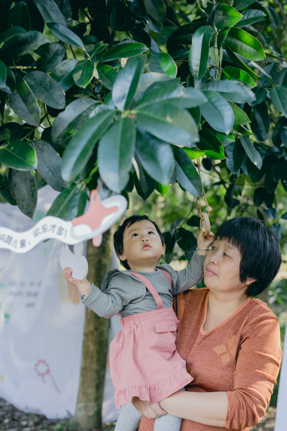 秋日去森林里赶了一个暖洋洋的集市
摄影：洪小漩
出镜：家人
场地：植物园
这是我初次带着菲比去参与杭州的集市。
杭城是个浪漫的地方，各种各样的展览，稀奇古怪的集市，很多都值得一去。
当日也是误打误撞到了植物园赶集。去的时候，人还不算很多。只是我缺乏一边带孩子，一边探索感兴趣事物的经验。
顾得住蹒跚学步的孩子，就分不开神去感受那些有趣的小铺子。
挣扎了一番，还是将看孩子放在了第一位。不过，整个活动氛围还是十分让人愉悦。待到阿科忙完工作，穿越堵车的街道抵达，我才得以坐下，听有趣的乐队轻吟浅唱。乐队成员说，能在森林里唱歌，是一件超妙的事。
对我而言，何尝不是呢。