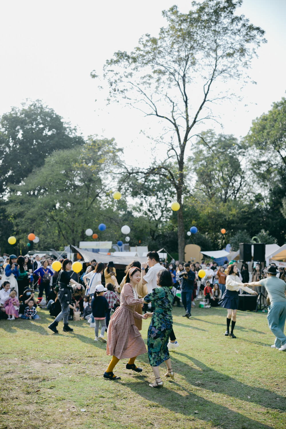 秋日去森林里赶了一个暖洋洋的集市
摄影：洪小漩
出镜：家人
场地：植物园
这是我初次带着菲比去参与杭州的集市。
杭城是个浪漫的地方，各种各样的展览，稀奇古怪的集市，很多都值得一去。
当日也是误打误撞到了植物园赶集。去的时候，人还不算很多。只是我缺乏一边带孩子，一边探索感兴趣事物的经验。
顾得住蹒跚学步的孩子，就分不开神去感受那些有趣的小铺子。
挣扎了一番，还是将看孩子放在了第一位。不过，整个活动氛围还是十分让人愉悦。待到阿科忙完工作，穿越堵车的街道抵达，我才得以坐下，听有趣的乐队轻吟浅唱。乐队成员说，能在森林里唱歌，是一件超妙的事。
对我而言，何尝不是呢。