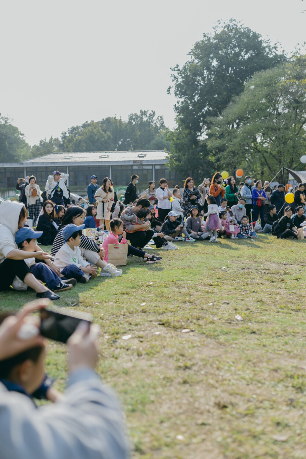 秋日去森林里赶了一个暖洋洋的集市
摄影：洪小漩
出镜：家人
场地：植物园
这是我初次带着菲比去参与杭州的集市。
杭城是个浪漫的地方，各种各样的展览，稀奇古怪的集市，很多都值得一去。
当日也是误打误撞到了植物园赶集。去的时候，人还不算很多。只是我缺乏一边带孩子，一边探索感兴趣事物的经验。
顾得住蹒跚学步的孩子，就分不开神去感受那些有趣的小铺子。
挣扎了一番，还是将看孩子放在了第一位。不过，整个活动氛围还是十分让人愉悦。待到阿科忙完工作，穿越堵车的街道抵达，我才得以坐下，听有趣的乐队轻吟浅唱。乐队成员说，能在森林里唱歌，是一件超妙的事。
对我而言，何尝不是呢。