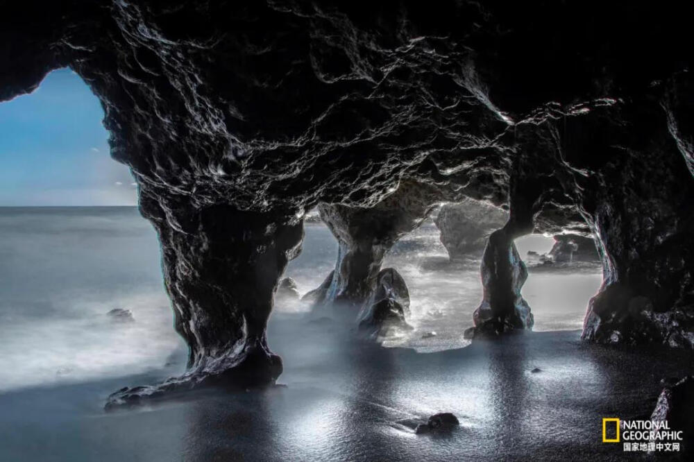 海滩奇景
在西班牙加那利群岛（Canary Islands）的海滩上，一束阳光勾勒出凹凸的石灰岩岩壁。由数百万年前的火山形成，群岛拥有丰富的自然海滩奇景，从潮汐雕刻的洞穴和黑色的沙湾到绿色的火山坑泻湖。摄影：EDUARDO ALBELO