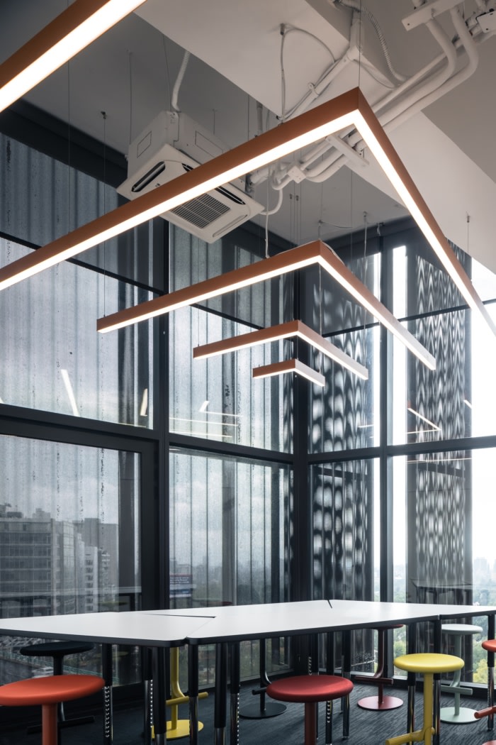 沿着主立面的灵活办公室可根据每个小公司的成员数量划分为不同大小的区域。另一个显着特点是开放式自助餐厅，里面有一个长长的酒吧，鼓励自由和自发的聚会。三角形的重点是头脑风暴室，里面的家具可以重新配置成不同的高度和布局，以改变创意会议中的交流动态。设计师想象干净的空间具有鲜明的色彩和光线对比。带有光泽和哑光、抛光和柔软饰面的白色、灰色、黑色和橙色为材料提供了基色，营造出干净、现代的外观。除了立面，封闭和私密的空间以白色为主，透明的玻璃隔断和门，将外立面的光线引入中央空间。