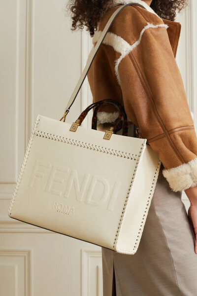 Fendi 這款 “Sunshine Shopper” 象牙色皮革手提包于品牌意大利工坊中制成，飾有別致醒目的 Logo 凹印壓花，仿玳瑁紋手柄兩端皆綴有低調(diào)的金色 “FF” 經(jīng)典標(biāo)志。包身容量充裕，足以為你妥善收納筆記本電腦和備用高…