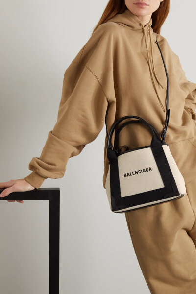 为减轻各位潮流女性的负担，Balenciaga 特地将 “'Navy Cabas” 手提包 改造成这一更为小巧轻盈的版本。单品以帆布制成，皮革边饰令包型更显立体有型，两侧的收缩设计可拓展包身容量。不妨将信用卡和零钱放入随附的…