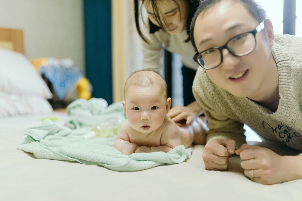 你好，了了
摄影：洪小漩
出镜：了了携家人
了了生日那天，正好是圣诞节。天空飘着雪，他爸爸妈妈忙着修热水器，于是，由他负责招待我这个初次见面的阿姨。了了很乖，不哭不闹，甚至还扬起笑脸对我小小。
白胖的小脸蛋，在空调房里，红彤彤地煞是好看。
认识了了爸爸多年，偶尔会在社交平台上刷到这大兄弟在弹奏乐器，尤其是了了妈妈孕期，他谈地格外卖力。这也给我一种误解，觉得，呵，好厉害。
但是，见面当天，我才知道，他还有很大上升空间。倒是了了妈妈，用尤克里里演奏起《葫芦娃》，嗯，可圈可点。
了了比菲比小了364天，却是一个处女座，一个天秤座。看着了了，我仿佛回到了一年前，菲比这个阶段的时候，有点想