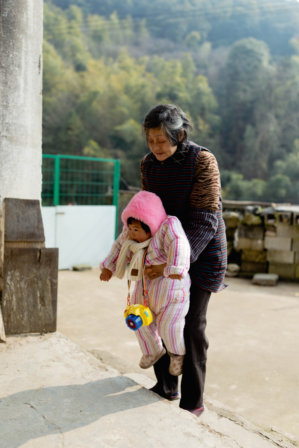 回乡下就得有个回乡下的样子
摄影：洪小漩
出镜：家人
今年过年，我们没有回浦江娘家。
我妈说，你们打杭州来的，别来浦江了，免得给疫情防控大局添麻烦。
谨遵母命，我们今年便在上虞待着，一动不动。
我知道妈妈很想念菲比，尤其担心菲比在山里阿太家会不会冷。于是，离杭前，我特意找出了压箱底的宝贝——妈妈早在菲比两个多月时候做的棉袄，将其一股脑儿揣进行李中。我计划让菲比穿了拍照，顺便想借此转告她外婆，我并不是觉得这衣服不好看才不给孩子穿的。
我妈乐忠于给菲比做衣服。在我临盆前，妈妈就织了数套毛衣，十几双鞋子，多顶帽子……我将其视作行为艺术，并不制止，只是让她注意身体，不要累坏了。
一针一