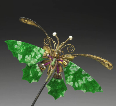 清 十九世纪翠玉蝴蝶簪，全长约26.5公分，宽16公分，台北故宫博物院藏。
翠玉制成几近透明的薄片，作为蝴蝶的双翅，玉质的纹理在光线中犹如蝴蝶天生的斑纹。金属片一方面将玉片固定再以线圈集结，另一方面制成蝴蝶的…
