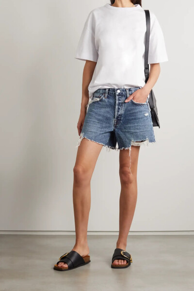 AGOLDE 这款短裤以有机棉和再生棉混纺而成，此种丹宁布对环境更为友好。裤身呈经典蓝色，经精心做旧和撕裂处理，呈现出久穿爱物般的岁月感，令人穿起来倍感亲切自在。