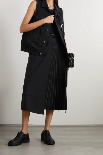 Ann Demeulemeester 的这款马甲以纯棉牛仔布裁成，结构轻巧，轮廓方正，便于叠穿。单品饰有银色纽扣和一条穿过翻领的罗缎带子，颇具品牌辨识度。不妨以黑色单品相搭，打造同色系造型。