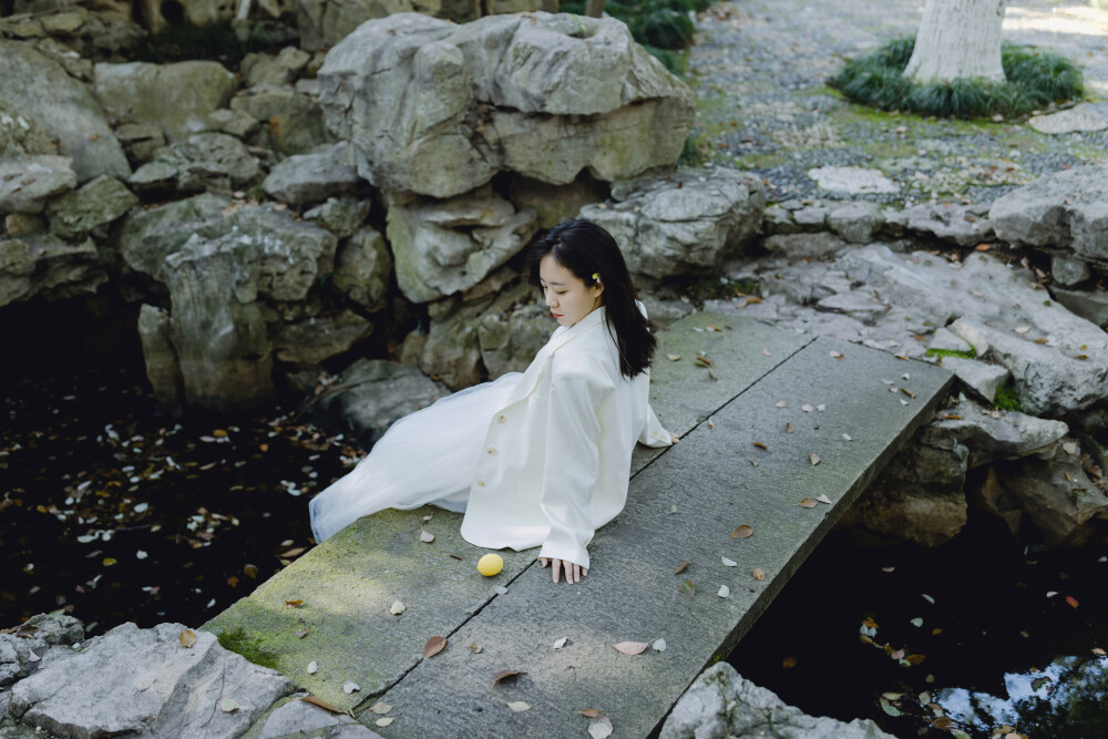 跑起来会有风
摄影：洪小漩
出镜：阿云
阿云那天来找我，是一个晴朗的下午。
她带了一瓶果酒，作伴手礼，包装很可爱，我等着找机会和朋友分享。
我把一堆裙子放在沙发上任她挑选，她选了这件白色的吊带，套上她的小西装，我们一起下了楼。
我家楼下就是墅园，在那里，我们邂逅了一道光。
我说，你站在光下，转圈。
于是，白色裙摆就像一朵花一样绽放起来，超治愈。
谢谢生活里出现的每一位美少女。
是她们的到来，陪我走过一段段琐碎的日子，偶尔陪伴我一路小跑，把烦恼抛诸脑后。