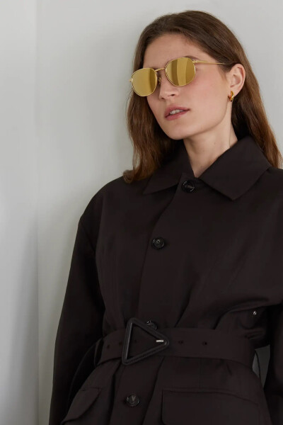 Bottega Veneta 这款镜面太阳镜采用金色圆框搭配金色镜片的同色组合，呈现出色彩统一的简约风格。纤细镜腿带有透明板材配件，可调节鼻垫确保佩戴舒适。