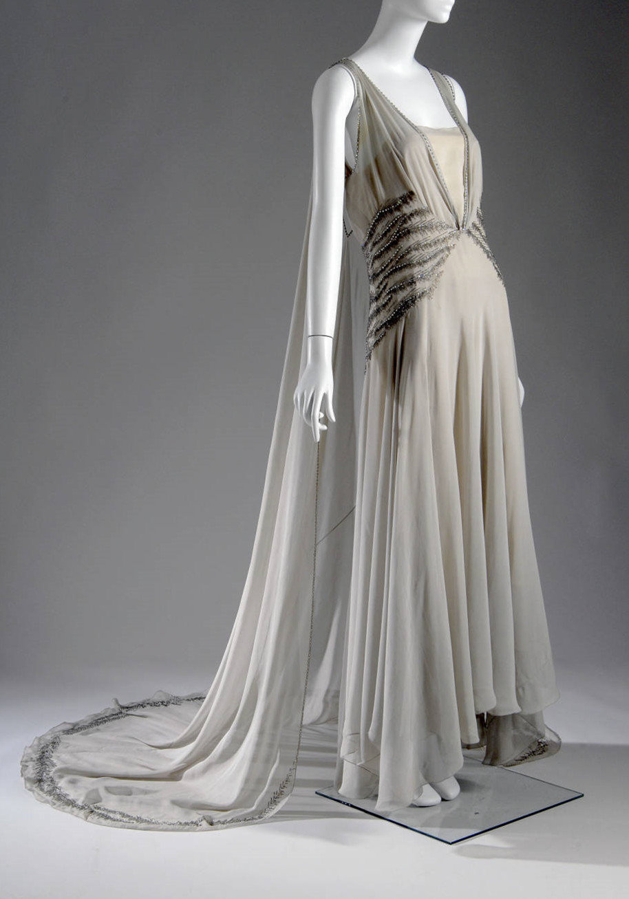 1930年代欧洲的服装女王——玛德琳·薇欧奈（Madeleine Vionnet，1876-1975）。薇欧奈发明了独特的“斜裁法（bias cut）”，充分利用布料的柔韧性和延展性塑造女性曲线，鼓励女性摆脱笨重的紧身胸衣，纽扣以及束带。同时她从古希腊艺术中吸取灵感，赋予时装以高贵而简洁的美感，她的许多服装都巧妙地一体制成，没有任何扣件，贴合灵动又自由飘逸，看似简洁实则需要花费大量的人工和精力。薇欧奈创造了30年代女性着装的新形态，V&A博物馆、大都会博物馆等都有收藏她的服装。