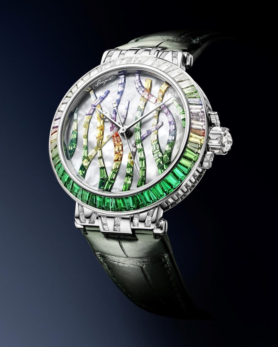 Breguet 宝玑「Marine Haute Joaillerie 9509 Poseidonia」灵感源自地中海特有的一种长寿水生植物「Posiddonia Oceanica 波西多尼亚海草」祖母绿版 搭配白色珍珠母贝表盘，镶嵌沙弗莱石、彩色蓝宝石和钻石，搭载自动上链机芯，35.8mm 白金表壳，厚度为10.46mm，85颗宝石连缀而成的海草图案，总重达2.56ct