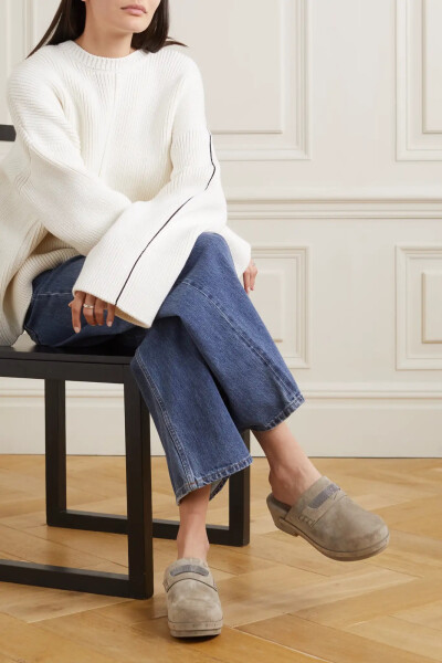 如果你是 Brunello Cucinelli 的忠实粉丝，定会认出这款圆头木屐袢带上的 Monili 镶珠。单品诞生于意大利，以柔软的绒面革精制而成，设有传统木质鞋底，独特的钉饰勾勒出精致品味，同时巧妙呼应品牌的经典风格。