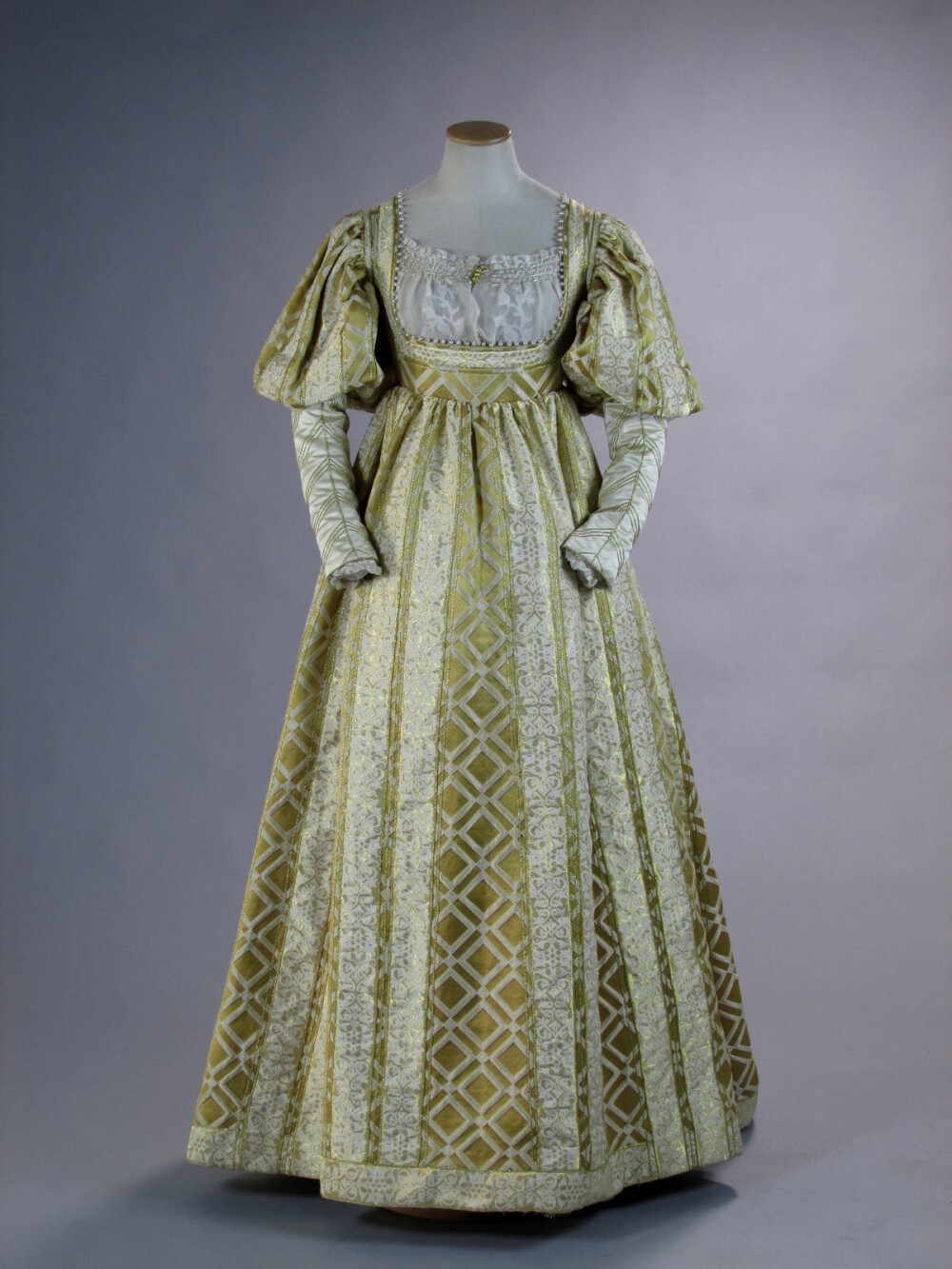 美版《波吉亚家族》第三季中卢克雷齐娅的婚服，一件1520年代风格的象牙色与金色织锦裙装，精美绝伦的花纹，高腰，领口则很低，缀有珍珠，袖子膨大呈灯笼状。在剧中还搭配了一个同色土耳其式头圈，意大利人称其为“balzo”。这件衣服非常华丽，但不符合历史，因为实际上这场婚礼是在1498年。 ​​​