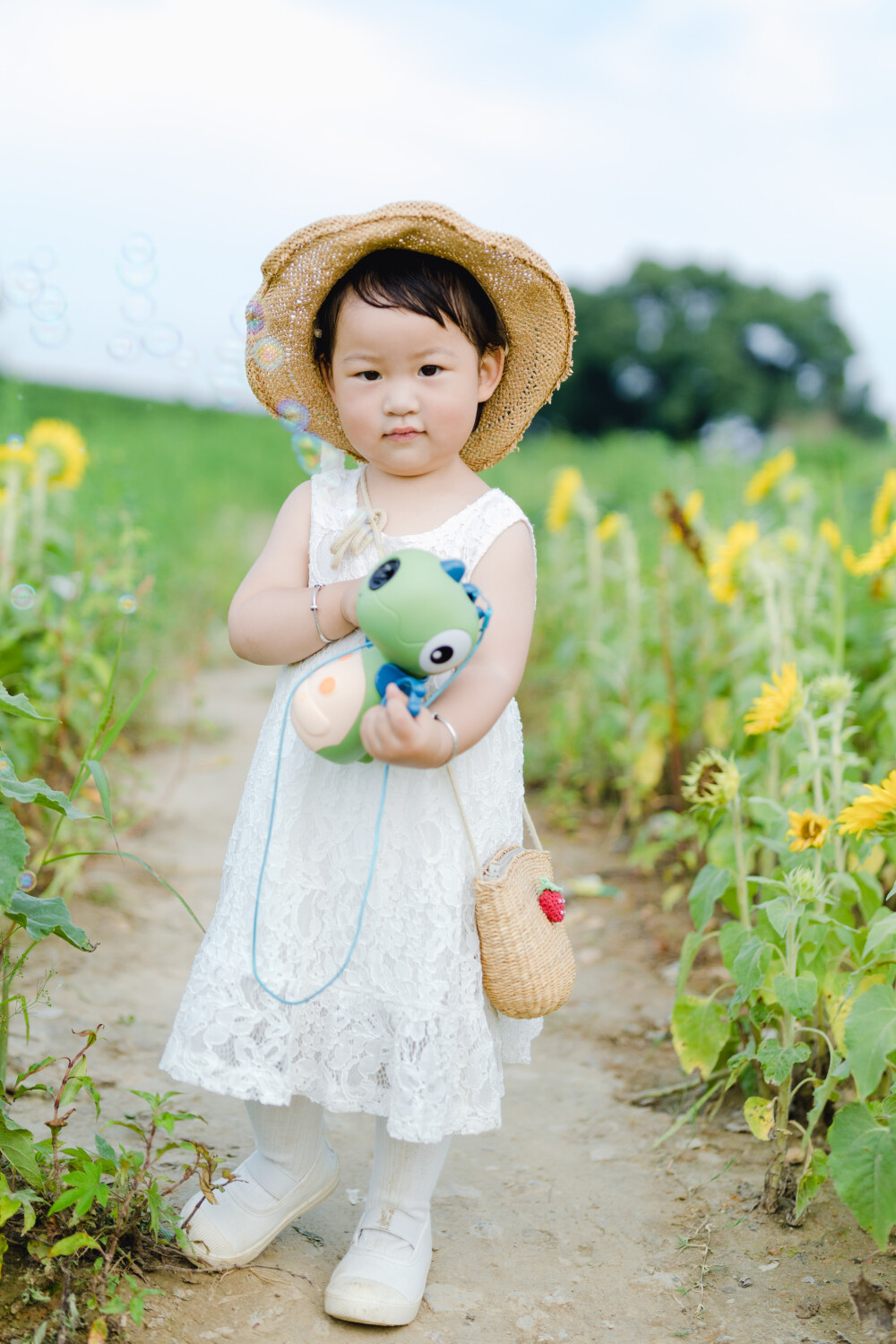 一眼好心情
摄影：洪小漩
出镜：菲比及家人
很小时候，我妈妈就曾种过一小片向日葵。
我太小，不知道那是自家的土地，放学后疯野到地里，站在巨大的花序下面，仰着头看着比我脸蛋子还大的一盘葵花籽，心想，什么时候可以吃。
后来，我将发现一片向日葵的事回家说与妈妈听，当她笑着告诉我那是她栽种的时，一股子莫名的骄傲在我心里油然而生。长大些，我才知道那是独属于我妈的浪漫。毕竟，只有她在自留地里栽种了一片明媚，耕种的人来来往往，都忍不住看两眼。
自此，我对向日葵有了执念。只可惜，我没有一片地像我妈那样可以自由栽种。
当得知杭州转塘有一片向日葵时，我便蓄谋，不论如何要带着菲比去看看。很幸运，成行了