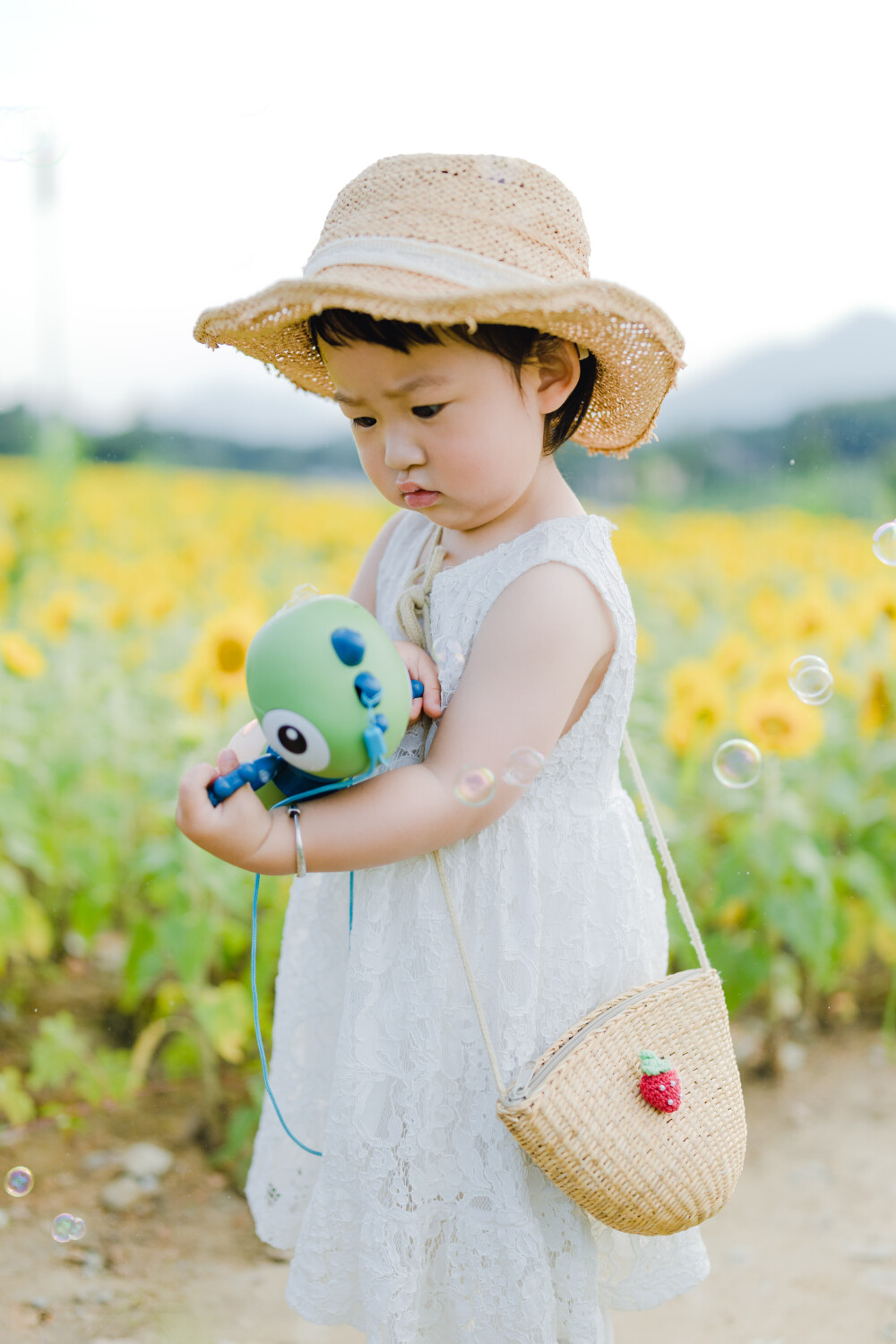 一眼好心情
摄影：洪小漩
出镜：菲比及家人
很小时候，我妈妈就曾种过一小片向日葵。
我太小，不知道那是自家的土地，放学后疯野到地里，站在巨大的花序下面，仰着头看着比我脸蛋子还大的一盘葵花籽，心想，什么时候可以吃。
后来，我将发现一片向日葵的事回家说与妈妈听，当她笑着告诉我那是她栽种的时，一股子莫名的骄傲在我心里油然而生。长大些，我才知道那是独属于我妈的浪漫。毕竟，只有她在自留地里栽种了一片明媚，耕种的人来来往往，都忍不住看两眼。
自此，我对向日葵有了执念。只可惜，我没有一片地像我妈那样可以自由栽种。
当得知杭州转塘有一片向日葵时，我便蓄谋，不论如何要带着菲比去看看。很幸运，成行了