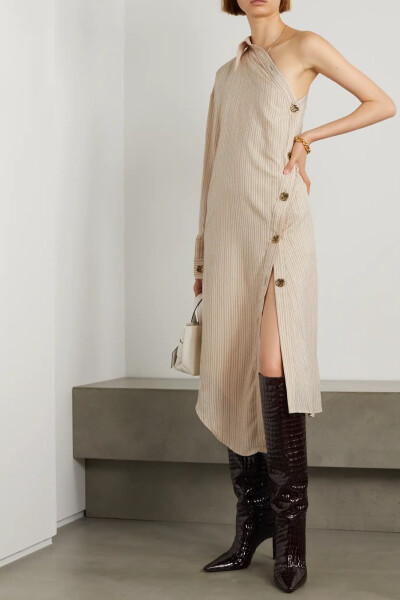 Acne Studios 这款衬衫式连衣裙可谓青出于蓝的创新佳作，为经典款式注入了满满新意。裙身织有细腻条纹，单袖设计和不对称裙摆互为呼应。经捶打压花的金色纽扣闪亮别致，不妨用珠宝与之相衬。