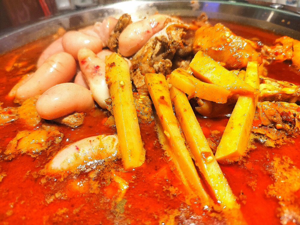 #昆明头条# 今年是疫情第三年，许多的餐厅火锅店都难以继续经营下去，闭店的很多。
而对于具有20年历史的读书铺酸笋鸡而言，今年是逆流而上的一年，今年布局南市区广福路的金广店是新开的第二家店，很是勇敢进取。
昨晚还在试营业，我们去的早，但是6：30已经坐满客人，生意很好。
金广店的装修风格与其他店不一样，它以鸡文化为主题，有很多复古怀旧之风，把上世纪小学的记忆、乡村的农家风格渲染得十分到位，让人感到情切、舒服。
金广店的产品依然是卖了20年的酸笋鸡，加上卤肥肠、新鲜大鸡腰、黄金洋芋，香辣酸爽、开胃爽口。