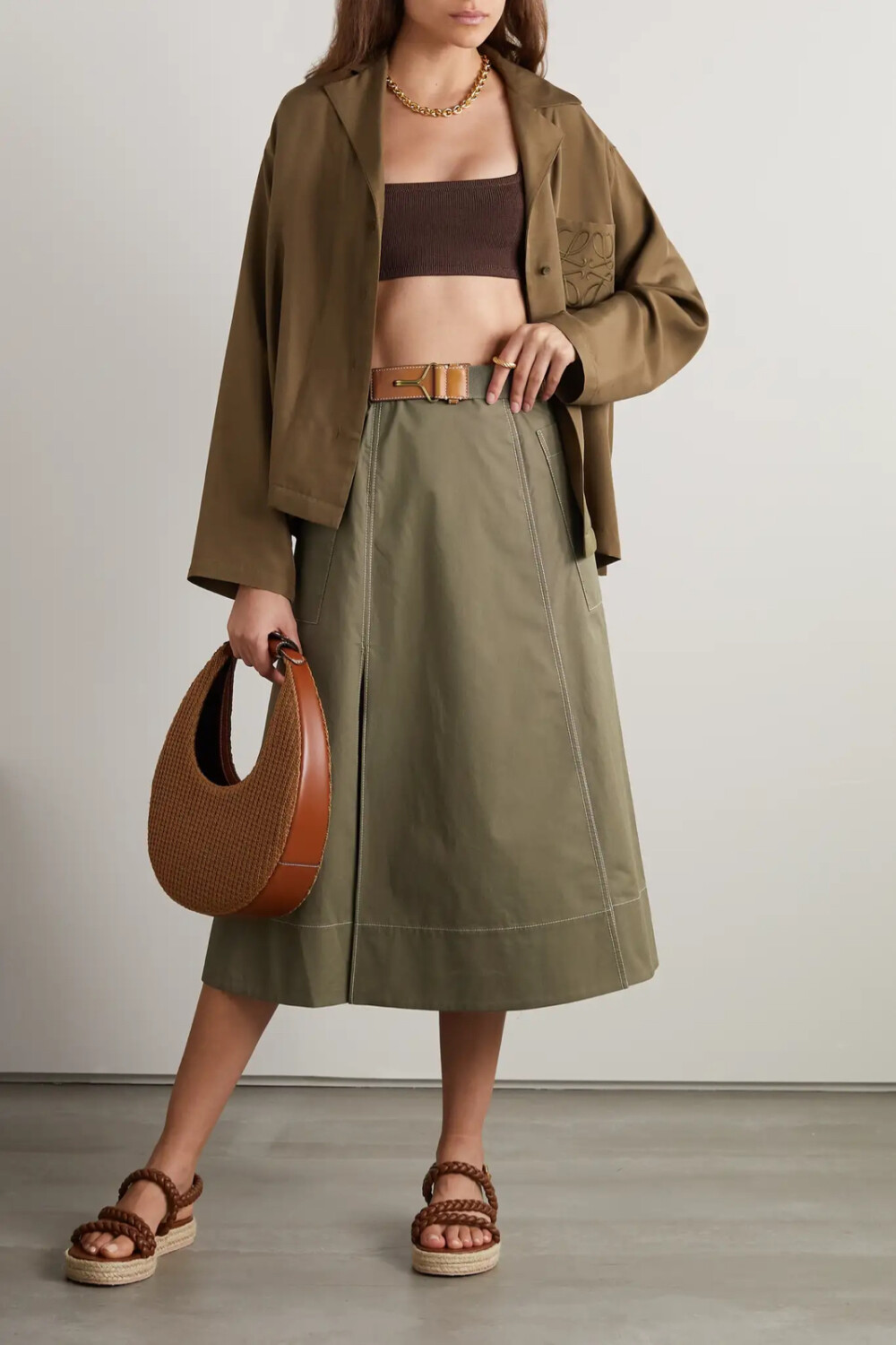 Tory Burch 这款中长半身裙散发出浓郁的复古风情，它以纯棉斜纹布裁就，挺括的面料质感令廓形更显立体，拼接设计巧妙加强丰盈感，饰有撞色明线的工装风口袋经典实用，皮革边饰腰带更添休闲韵味。