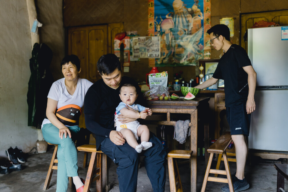 小团圆
摄影：洪小漩
出镜：家人
拖延症真是害人不浅。
杨梅时节已过，我上一次回家的照片还来不及整理。有时候一耽误，记忆中的细节便作鸟兽散，无影无踪。
上次回家，阿科招呼了堂弟带大胖儿子来奶奶家吃饭摘杨梅。菲比也总算和许久不见的弟弟再度会面。她丝毫不介意大家的注意力都被弟弟所吸引，而是围着弟弟绕圈，摸摸小手，戳戳小脚丫子，心满意足。
阿科找出了家中被老鼠啃咬出老大窟窿的地龙，请小叔帮忙修补，两个人折腾好一通，最后用十分粗糙的手艺，补了个大概。
午饭后，阿科和小叔、堂弟、大春爷爷一道去山上摘杨梅，问我，要不要同去。怕热又想记录的我好一通犹豫，最后一咬牙，换上长衫长袖上了山，除了相机