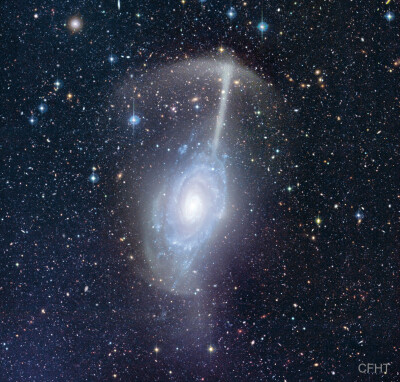 NGC 4651 雨伞星系 这个庞大形似雨伞的天体结构，其实是从伴星系剥离出来的恒星潮汐流。主体螺旋星系NGC 4651的大小与我们的银河系差不多，而它的星雨之伞在这个星系明亮的圆盘上方延展出大约10万光年的长度。当某个…