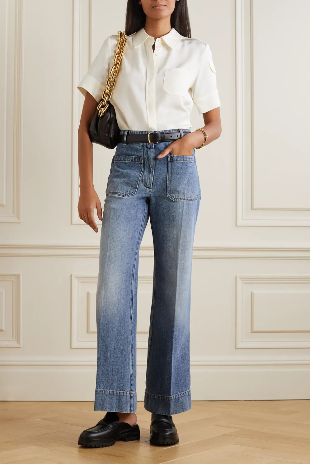 Victoria Beckham 的 “Alina” 牛仔裤版型独具一格，迅速成为了品牌人气作品。这一版本采用蓝色丹宁布，高腰阔腿裤身上带有实用主义风贴袋。不妨将衬衫掖入裤腰，再搭配高跟鞋。