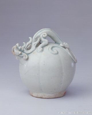 景德镇窑青白釉倒流壶，宋，高11.2cm，足径6cm。 壶体呈瓜棱球形，一条堆塑其上的螭龙巧妙地形成壶流与提梁，平底，底中心有一注酒的圆洞。通体施青白釉，釉色白中泛青。 此壶设计巧妙，因利用连通器原理，注酒时将壶倒置，从底孔注酒后，再将壶正置，即可从螭龙嘴往外倒酒，故称“倒流壶”。 