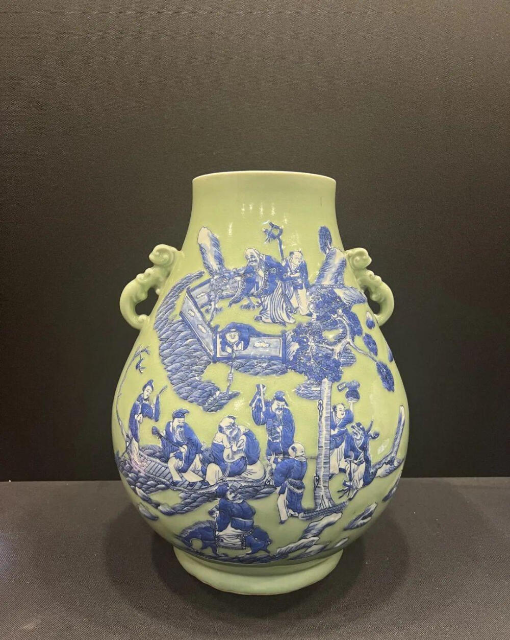 清嘉庆 豆青地青花加白八仙祝寿图双耳尊
尺寸：高：46.5cm
此尊器型硕大，伟岸大气。胎质坚实洁白，釉层肥厚。青花夹白又称堆粉青花，是指在豆青釉青花瓷器中增加了青花堆白粉或者说是青花加白的制瓷工艺。本罐其烧制方法是，先在器胎表面上，按花纹图案的大致形状施一层白粉料，然后，在白粉料上面绘画青彩或点缀红彩纹饰，再给图案纹饰之外空地广布豆青釉彩，最后施透明釉入窑烧制。八仙贺寿是一个民间传说，意思是李铁拐、钟离权、张果老、吕洞宾、何仙姑、蓝采和、韩湘子和曹国舅八位仙人前往瑶池向王母贺寿，画工精湛，人物传神，精品之作。马未都先生旧藏一款双耳尊与此品形制、纹饰相同，可供参考。