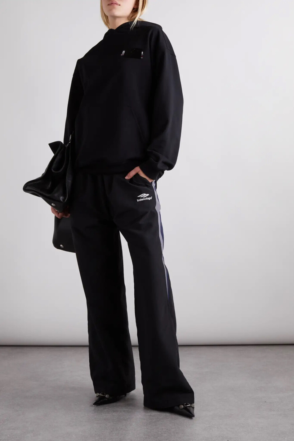 Balenciaga 这款帽衫以纯棉平纹布制成，胸前点缀着黑色版本的品牌特色政治标语风 Logo。大廓形衣身设有便利的袋鼠兜袋和抽绳兜帽，别具潇洒酷感。不妨搭配阔腿牛仔裤或休闲裤，再以老爹鞋相衬。