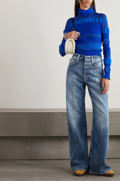 Acne Studios 这款高腰阔腿牛仔裤裁自质地硬挺、不易变形的丹宁布，褪色裤筒的微微仿旧设计散发出久穿爱物般的复古气息，车缝裤褶令裤腿线条更显流畅笔挺。
