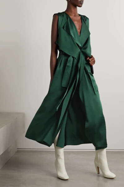 Victoria Beckham 这款裹身连衣裙以永不过时的经典款风衣为灵感，采用 “Bottle Green” 墨绿色女公爵缎裁就，垂顺典雅的衣身设有交叉驳头和后背过肩，随附腰带恰可用于收束宽松廓形，让整体更显利落干练。不妨从品…