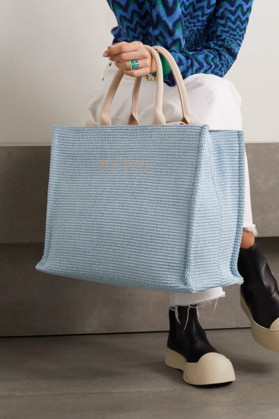 Marni 这款容量充裕的 “Basket” 手提包可一举收入你的各式随身物品，再加上 iPad 和你常看的生活杂志亦卓卓有余。它以棉质混纺纤维织就，却呈现拉菲草般的质感，散发出满满的夏日气息，尤其适合伴你在海滩休憩或游…