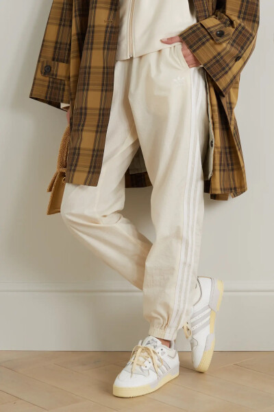 adidas Originals 这款 “Rivalry Low '86” 运动鞋样式经典，兼具迷人复古气息与现代时髦感。单品以中性色调皮革拼接而成，鞋面采用穿孔设计，经典三道杠条纹和 Logo 刺绣鞋舌彰显品牌身份。简约百搭的它可搭配精裁…