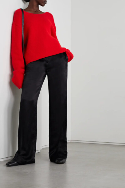 The Row 这款 “Iri” 毛衣以红色羊绒织就，质感软糯、色彩明艳。它呈宽松短款廓形，衣袖加长，低露背设计随性自在。不妨随心搭配高腰牛仔裤、利落西裤等各式单品。