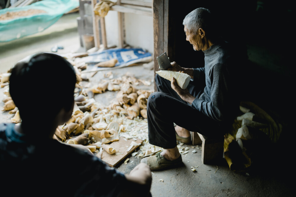 梅菜笋干的香味你闻到了吗
摄影：洪小漩
出镜：家人
这是一次特别的聚会。有心心念念一年，说想去看看笋干梅菜制作流程的羽希。有对外孙女思念成疾最后驱车来上虞把孩子“掳走”的老爸老妈。
爸爸妈妈一早从浦江出发，我们则一早赶到镇上买菜。最后，在前后脚不差
三分钟的时间内同时抵达村口。
因为修路的原因，只能将车子停在距离家稍远处，由阿科借了三轮车将父母带来的各种伴手礼以及想兜风的菲比载回家。我们则慢慢走着。
父母一边走一边感叹村里漫山遍野的竹子，以及拔地而起的春笋。到了家门口，越靠近爷爷奶奶家，梅菜笋干的香味越是冲着鼻子往里钻。
我带着爸妈往山坡上散步，妈妈和羽希邂逅一片蕨菜，不亦乐乎