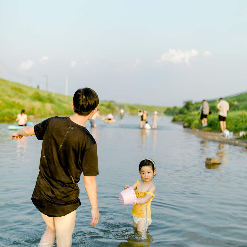 盛夏渣河墩
摄影：洪小漩
出镜：家人朋友
地址：渣河墩
盛夏，和朋友一起露营、嬉水、烧烤是我心心念念的事。
这个约，我们至少计划了半年之久。主要在于敲定三家的时间。
好不容易确定好了，高温也如期而至。三户人家从一开始的兴致勃勃，到后来的一直问“水呢、水在哪里？”最终，我们都像是挂在椅子和地垫上的抹布，只会哼哼。
最开心的恐怕就是两个在水里泡了一天的崽崽。水枪、水桶、网兜，便可以玩上一整天。其次，就是频繁在上下游穿梭钓鱼放地龙的阿科。少年心性，他开心就好。
结结实实晒了一天，又黑两个度，这是这个夏天送我的第一份大礼。