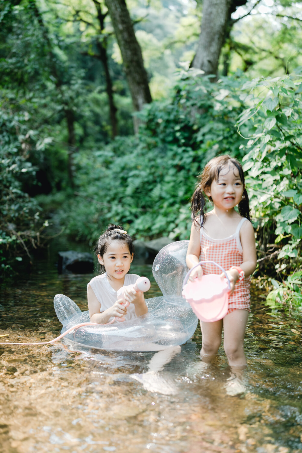 夏天總是要去九溪的
攝影：洪小漩
出鏡：菲比和格格等
每年夏天，九溪都是必去之地。
曾經(jīng)，打車是可以直達(dá)九溪煙樹(shù)的。如今，想要驅(qū)車前往，必須提前預(yù)約。或是統(tǒng)一乘坐觀光車進(jìn)入。
今日份阿科出差，兩個(gè)三口之家的出行便缺了一個(gè)壯勞力，少了一分從容。
三個(gè)大人提著裝備吃食，外加菲比三不五時(shí)鬧著要抱，我們便索性絕了步行進(jìn)入的念頭，半程觀光車，半程徒步，總算找了一小片人不算多的水域。
阿科不在，張羅菲比的我顯得十分狼狽。不過(guò)，小朋友玩得盡興，別的也就無(wú)所謂了。
一只小桶、一把水槍、一個(gè)游泳圈、一個(gè)西瓜，夏天那味便有了七八分。剩下的便是聒噪的蟬鳴和潺潺的流水。這不，今日都齊了。