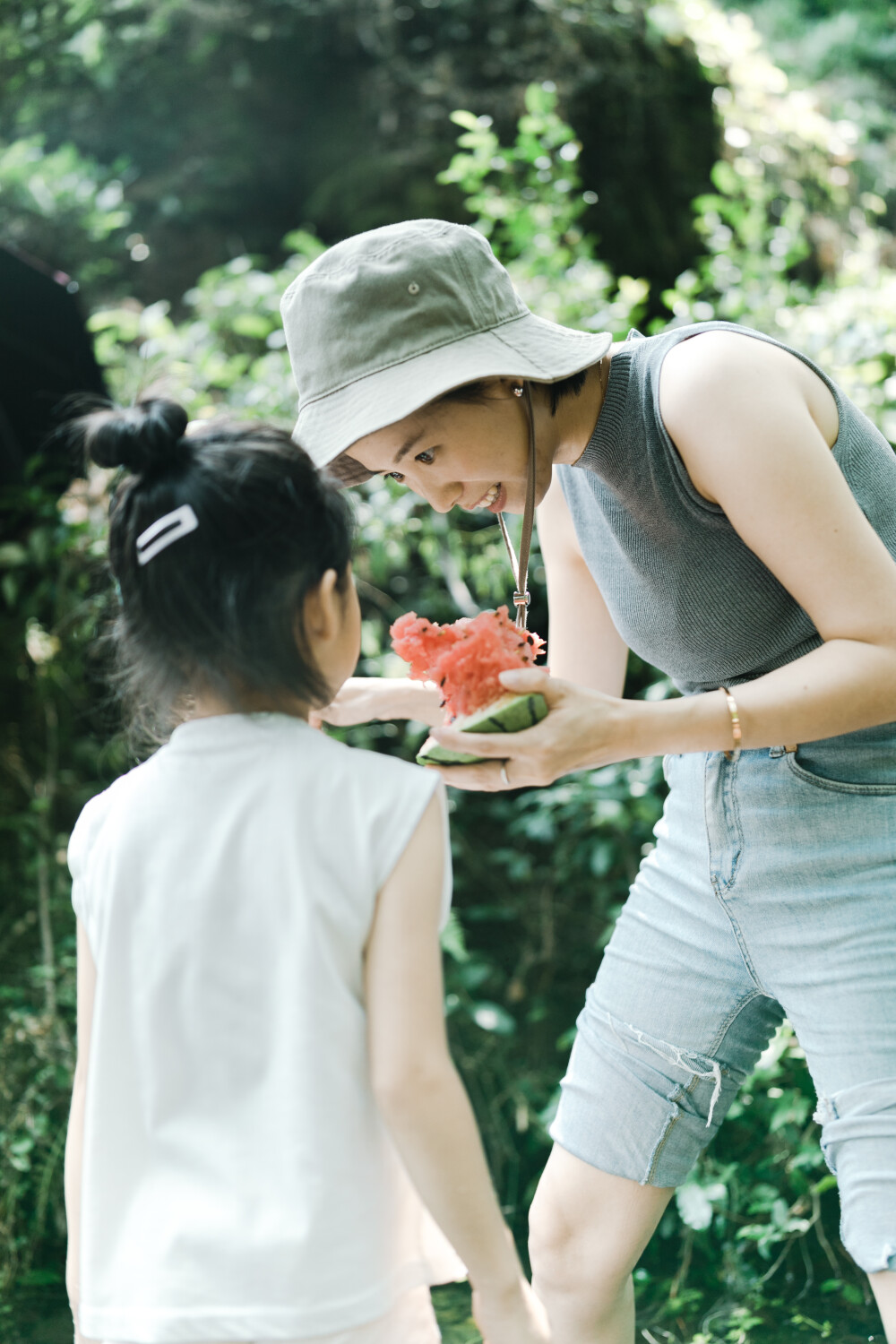 夏天总是要去九溪的
摄影：洪小漩
出镜：菲比和格格等
每年夏天，九溪都是必去之地。
曾经，打车是可以直达九溪烟树的。如今，想要驱车前往，必须提前预约。或是统一乘坐观光车进入。
今日份阿科出差，两个三口之家的出行便缺了一个壮劳力，少了一分从容。
三个大人提着装备吃食，外加菲比三不五时闹着要抱，我们便索性绝了步行进入的念头，半程观光车，半程徒步，总算找了一小片人不算多的水域。
阿科不在，张罗菲比的我显得十分狼狈。不过，小朋友玩得尽兴，别的也就无所谓了。
一只小桶、一把水枪、一个游泳圈、一个西瓜，夏天那味便有了七八分。剩下的便是聒噪的蝉鸣和潺潺的流水。这不，今日都齐了。