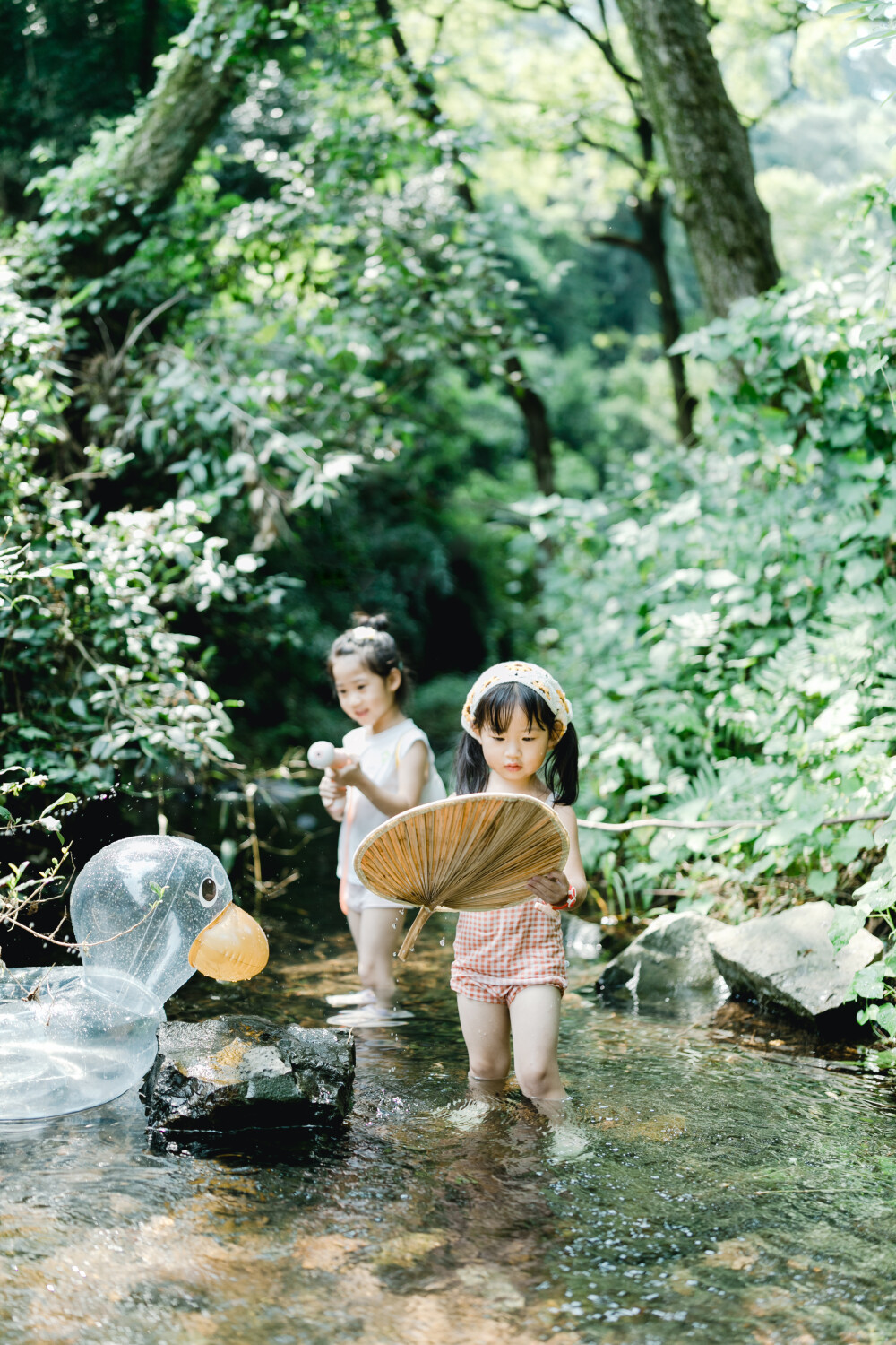 夏天總是要去九溪的
攝影：洪小漩
出鏡：菲比和格格等
每年夏天，九溪都是必去之地。
曾經(jīng)，打車是可以直達九溪煙樹的。如今，想要驅(qū)車前往，必須提前預約?；蚴墙y(tǒng)一乘坐觀光車進入。
今日份阿科出差，兩個三口之家的出行便缺了一個壯勞力，少了一分從容。
三個大人提著裝備吃食，外加菲比三不五時鬧著要抱，我們便索性絕了步行進入的念頭，半程觀光車，半程徒步，總算找了一小片人不算多的水域。
阿科不在，張羅菲比的我顯得十分狼狽。不過，小朋友玩得盡興，別的也就無所謂了。
一只小桶、一把水槍、一個游泳圈、一個西瓜，夏天那味便有了七八分。剩下的便是聒噪的蟬鳴和潺潺的流水。這不，今日都齊了。