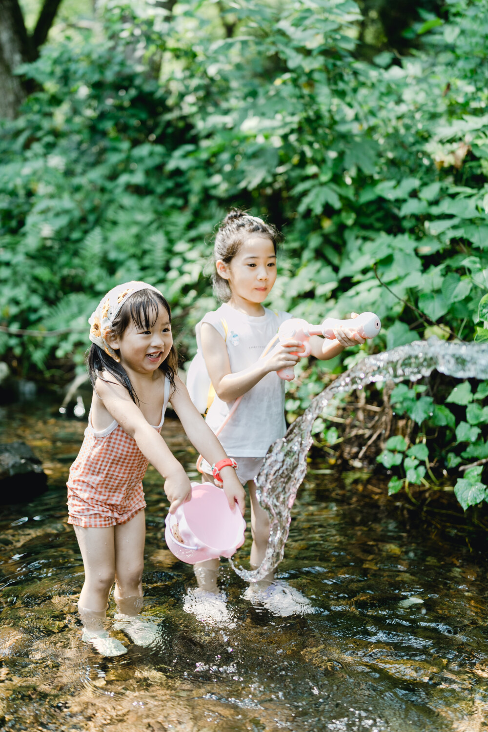 夏天总是要去九溪的
摄影：洪小漩
出镜：菲比和格格等
每年夏天，九溪都是必去之地。
曾经，打车是可以直达九溪烟树的。如今，想要驱车前往，必须提前预约?；蚴峭骋怀俗酃獬到搿?今日份阿科出差，两个三口之家的出行便缺了一个壮劳力，少了一分从容。
三个大人提着装备吃食，外加菲比三不五时闹着要抱，我们便索性绝了步行进入的念头，半程观光车，半程徒步，总算找了一小片人不算多的水域。
阿科不在，张罗菲比的我显得十分狼狈。不过，小朋友玩得尽兴，别的也就无所谓了。
一只小桶、一把水枪、一个游泳圈、一个西瓜，夏天那味便有了七八分。剩下的便是聒噪的蝉鸣和潺潺的流水。这不，今日都齐了。