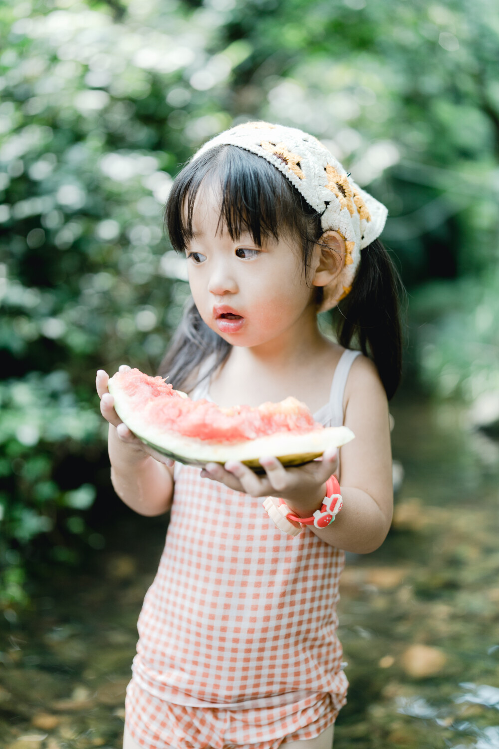 夏天总是要去九溪的
摄影：洪小漩
出镜：菲比和格格等
每年夏天，九溪都是必去之地。
曾经，打车是可以直达九溪烟树的。如今，想要驱车前往，必须提前预约。或是统一乘坐观光车进入。
今日份阿科出差，两个三口之家的出行便缺了一个壮劳力，少了一分从容。
三个大人提着装备吃食，外加菲比三不五时闹着要抱，我们便索性绝了步行进入的念头，半程观光车，半程徒步，总算找了一小片人不算多的水域。
阿科不在，张罗菲比的我显得十分狼狈。不过，小朋友玩得尽兴，别的也就无所谓了。
一只小桶、一把水枪、一个游泳圈、一个西瓜，夏天那味便有了七八分。剩下的便是聒噪的蝉鸣和潺潺的流水。这不，今日都齐了。