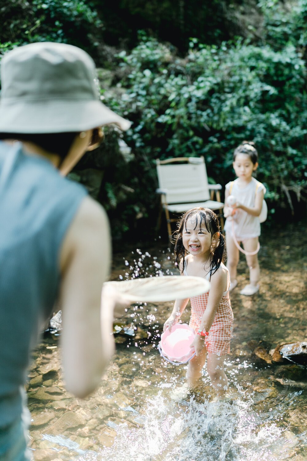 夏天总是要去九溪的
摄影：洪小漩
出镜：菲比和格格等
每年夏天，九溪都是必去之地。
曾经，打车是可以直达九溪烟树的。如今，想要驱车前往，必须提前预约。或是统一乘坐观光车进入。
今日份阿科出差，两个三口之家的出行便缺了一个壮劳力，少了一分从容。
三个大人提着装备吃食，外加菲比三不五时闹着要抱，我们便索性绝了步行进入的念头，半程观光车，半程徒步，总算找了一小片人不算多的水域。
阿科不在，张罗菲比的我显得十分狼狈。不过，小朋友玩得尽兴，别的也就无所谓了。
一只小桶、一把水枪、一个游泳圈、一个西瓜，夏天那味便有了七八分。剩下的便是聒噪的蝉鸣和潺潺的流水。这不，今日都齐了。