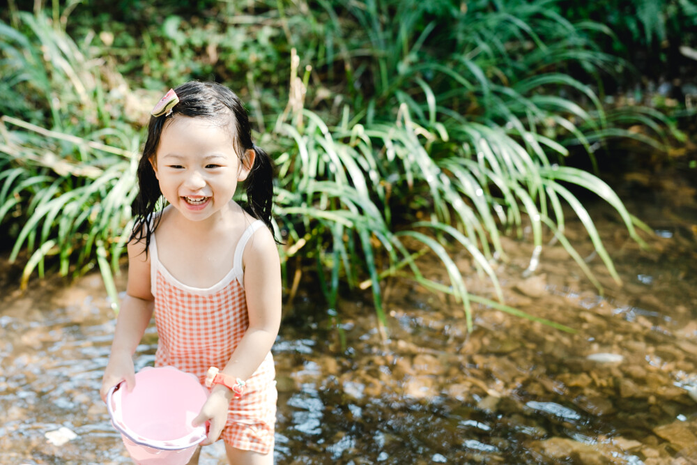 夏天總是要去九溪的
攝影：洪小漩
出鏡：菲比和格格等
每年夏天，九溪都是必去之地。
曾經(jīng)，打車是可以直達(dá)九溪煙樹(shù)的。如今，想要驅(qū)車前往，必須提前預(yù)約?；蚴墙y(tǒng)一乘坐觀光車進(jìn)入。
今日份阿科出差，兩個(gè)三口之家的出行便缺了一個(gè)壯勞力，少了一分從容。
三個(gè)大人提著裝備吃食，外加菲比三不五時(shí)鬧著要抱，我們便索性絕了步行進(jìn)入的念頭，半程觀光車，半程徒步，總算找了一小片人不算多的水域。
阿科不在，張羅菲比的我顯得十分狼狽。不過(guò)，小朋友玩得盡興，別的也就無(wú)所謂了。
一只小桶、一把水槍、一個(gè)游泳圈、一個(gè)西瓜，夏天那味便有了七八分。剩下的便是聒噪的蟬鳴和潺潺的流水。這不，今日都齊了。